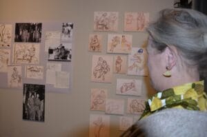 Ann Olander tittar på skisser av kvinnor.