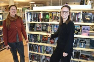 Therese Nylén och Anna Höglund visar upp hyllan med spänningsböcker på Säters bibliotek.