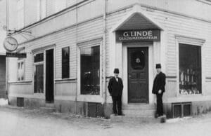 I 92 år låg företaget i hörnet av Målaregatan och Sveagatan. Här syns butiksägaren Gotlieb Lindé själv till höger på bilden.