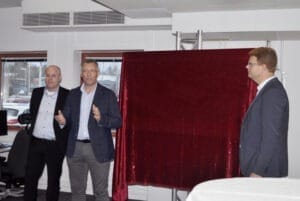 Tobias Hansson, Niklas Persson och Fredrik Rönning framför skärmbild på den nya fabriken.