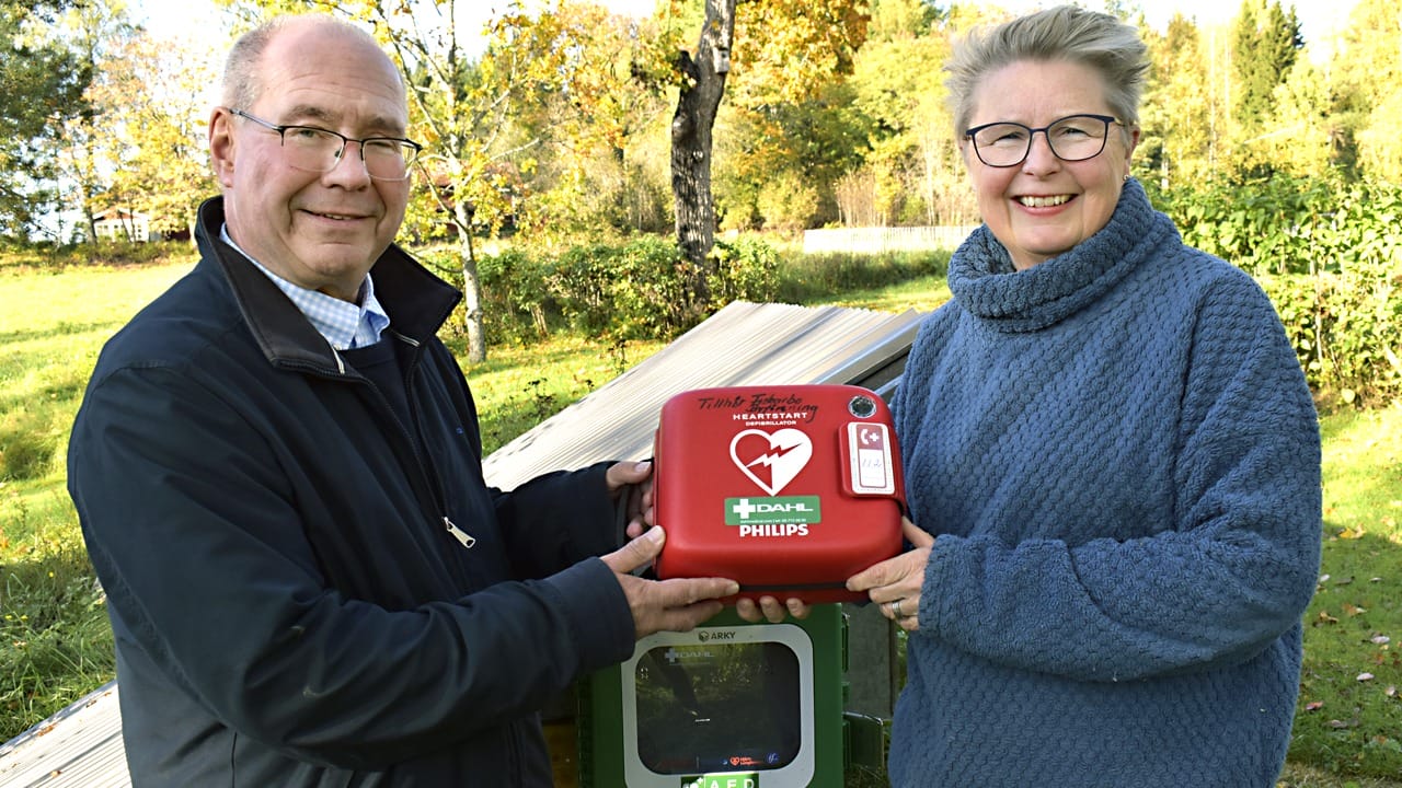 Claes Perrault och Ulla-Kari Pontén visar upp den hjärtstartare som nyligen kom på plats i Fiskarbo.