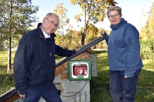 Claes Perrault och Ulla-Kari Pontén visar upp den hjärtstartare som nyligen kom på plats i Fiskarbo.